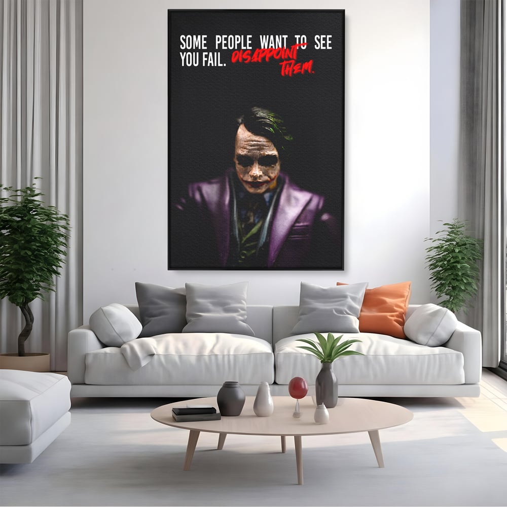 Tablou canvas cu tablou canvas cu joker si mesaj motivational, in rama de aluminiu negru, pe perete intr-un living